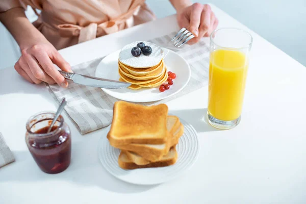 Vista Cortada Mulher Tomando Café Manhã Com Panquecas Suco Laranja — Fotografia de Stock