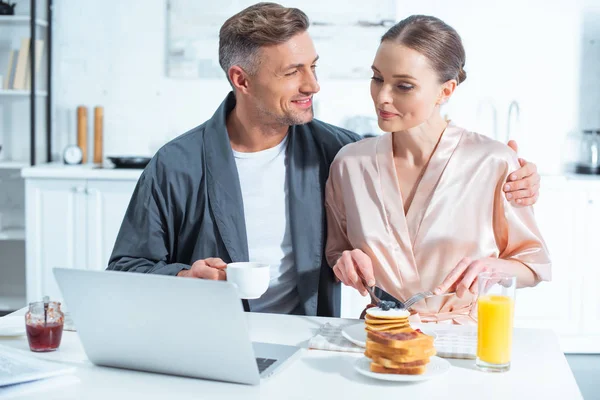 Adult Couple Robes Sitting Table Laptop While Having Breakfast Kitchen — Stock Photo, Image