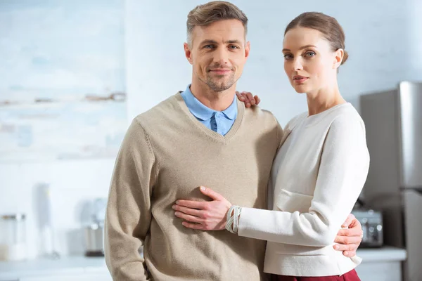 Pareja Adulta Ropa Casual Mirando Cámara Abrazándose Cocina — Foto de Stock