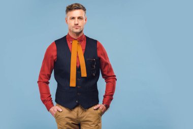 formal giyim yakışıklı şık erkekte elleri ceplerinde mavi izole kamera bakıyor