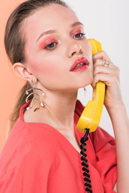 güzel moda kız retro oturma telefonla konuşurken arka plan üzerinde mercan