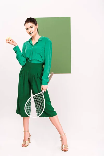 背景の海緑のポーズをしながら硬式テニスボール ラケットを保持しているスタイリッシュな美人 — ストック写真