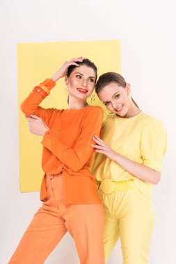 arka plan üzerinde ilgi odağı ile poz gülümseyen moda kızlar