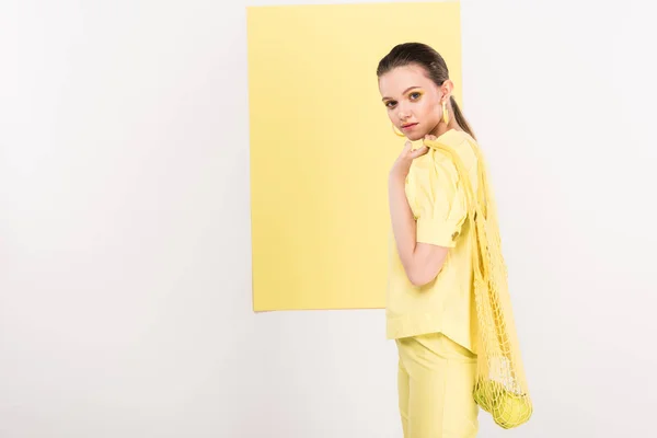有吸引力的时尚女孩拿着串袋与苹果 而摆姿势与聚光灯背景 — 图库照片