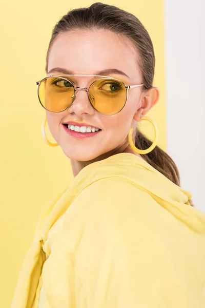 Mooie Modieuze Meisje Zonnebril Glimlachend Poseren Met Schijnwerpers Achtergrond — Stockfoto