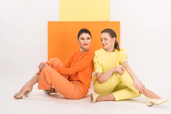 Meninas Bonitas Elegantes Sentado Posando Com Açafrão Ribalta Fundo — Fotografia de Stock