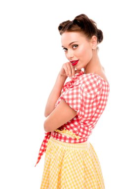 Stylish pin up girl holding hand on cheek and looking at camera isolated on white