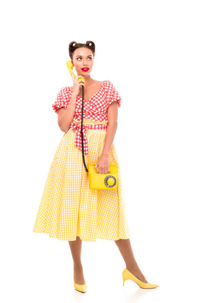 Beautiful talking on vintage yellow phone while standing on high heels