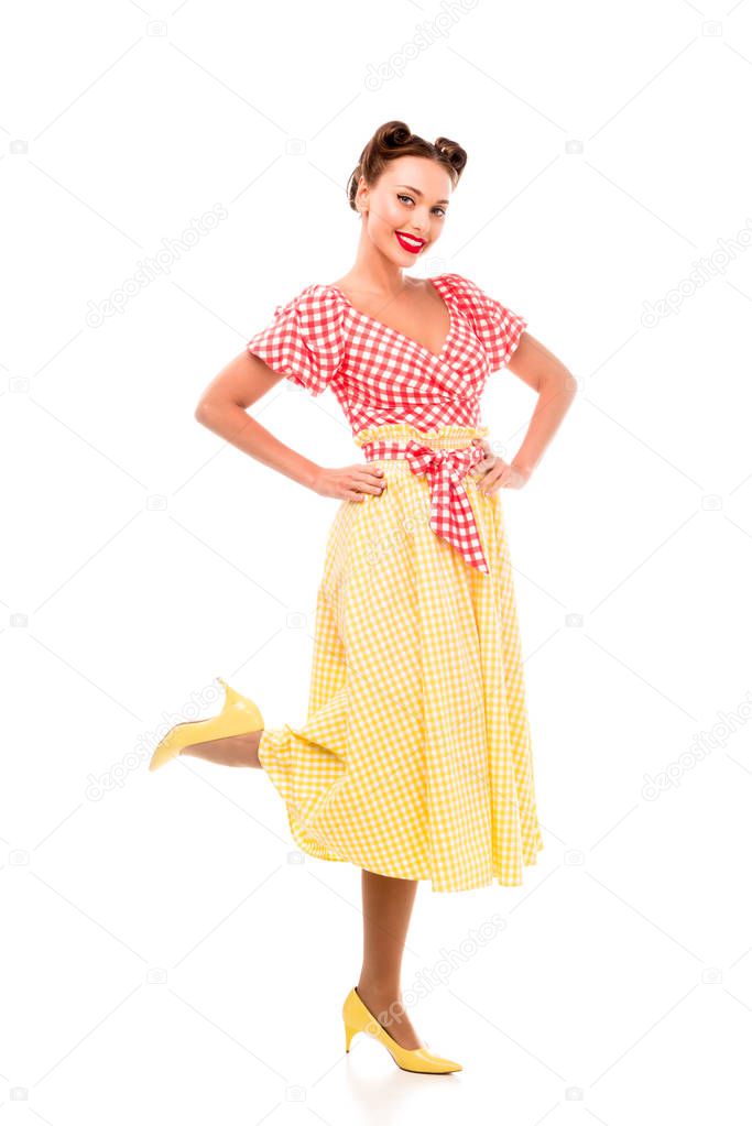 Stylish pin up girl posing on high heels and holding hands on hips isolated on white