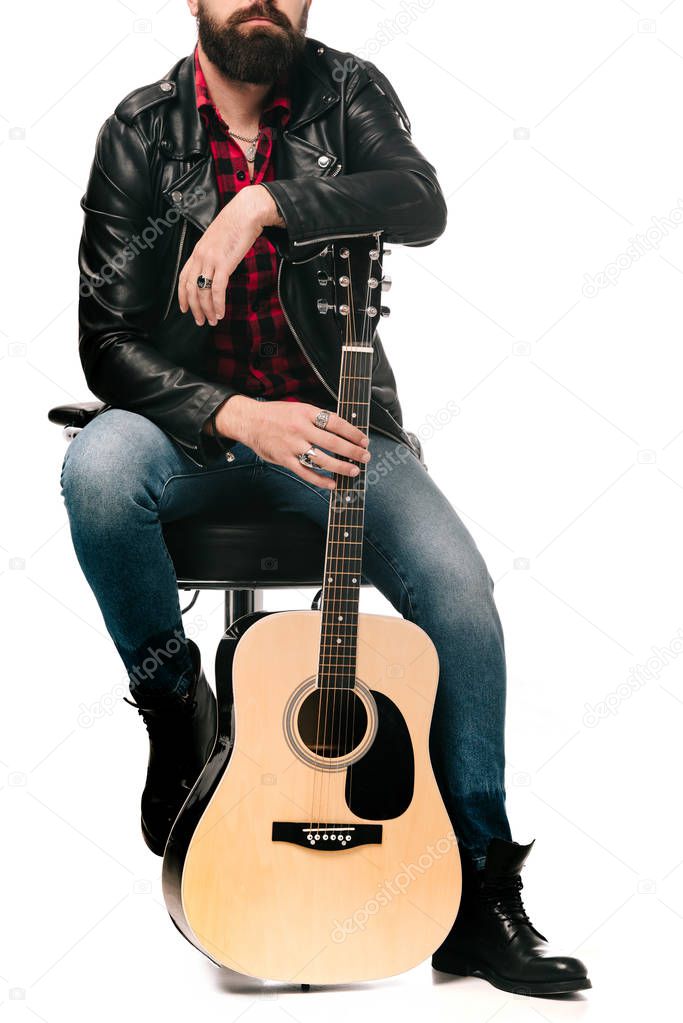 cropped view of musician in black leather jacket posing with acoustic guitar, isolated on white
