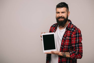 Dijital tablet boş ekran ile gösterilen kareli gömlekli adam gülümsüyor, gri izole