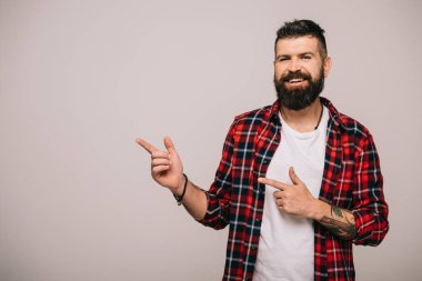 gülümseyen adam bir şey gri izole gösterilen kareli gömlekli sakallı  