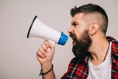 handsome angry man yelling into megaphone, isolated on grey clipart