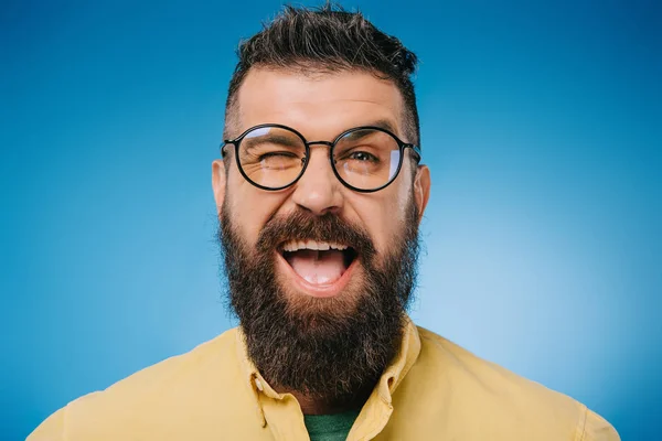 Opgewonden Bebaarde Man Brillen Winking Geïsoleerd Blauw — Stockfoto