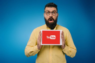 şaşırmış sakallı adam gösteren dijital tablet ile youtube uygulaması, mavi izole 