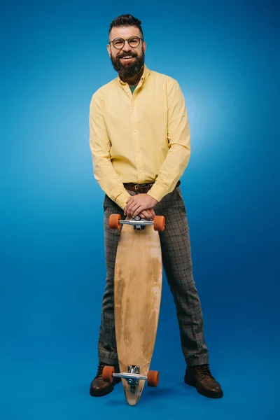 Γενειοφόρος Χαμογελαστός Άνθρωπος Κρατώντας Skateboard Που Απομονώνονται Μπλε — Φωτογραφία Αρχείου