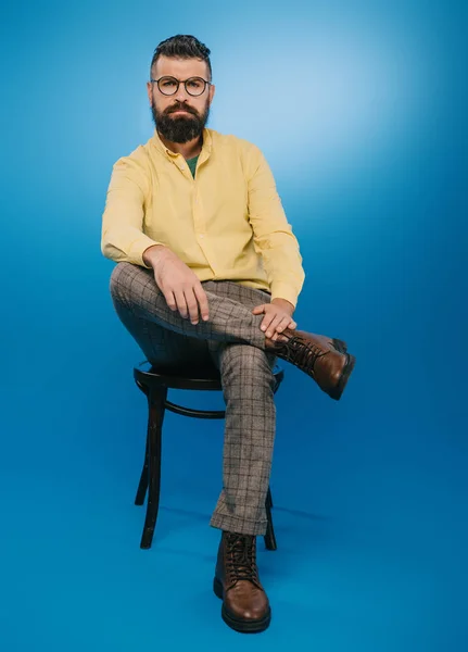 Stylish Bearded Man Glasses Sitting Chair Isolated Blue — Stock Photo, Image