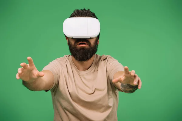 Hombre Barbudo Haciendo Gestos Usando Auriculares Realidad Virtual Aislados Verde —  Fotos de Stock