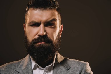 yakışıklı sakal işadamı kahverengi üzerine izole kamera bakıyor