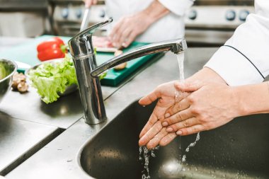 kadın şef üzerinde restoran mutfak lavaboda el yıkama kırpılmış görünümünü