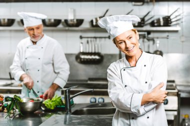 güzel kadın aşçı ve Restoran mutfağında yemek sırasında kruvaze ceketler erkek şefi 