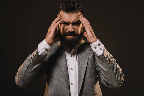 stylish beard businessman having headache isolated on brown