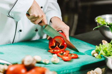 kadın şef mutfakta biber doğrama görünümünü kırpılmış