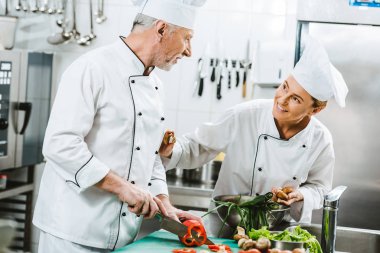 kadın ve erkek şefler üniforma ve Restoran mutfağında yemek şapkalar