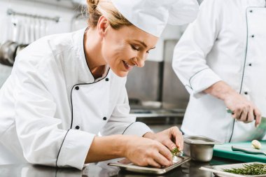 güzel gülümseyen kadın şef yemek restoran mutfak ot ile dekorasyon üniformalı