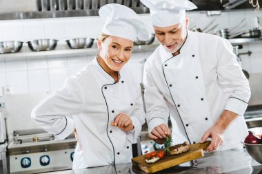 eti biftek restoran mutfak ahşap tahta üzerinde üniformalı kadın ve erkek şefler