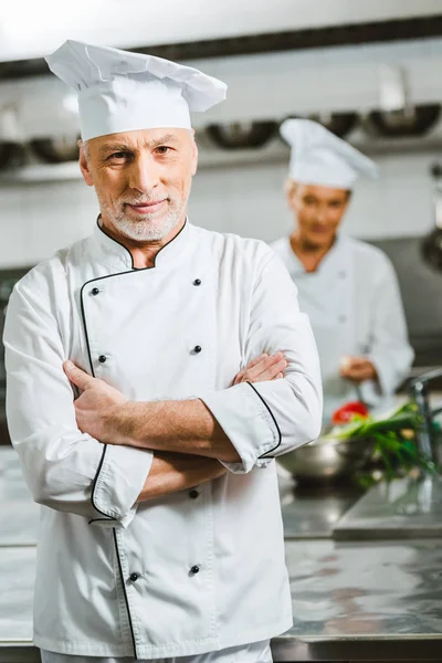 Lokanta Mutfağı Kamerada Bakarak Kollu Üniformalı Yakışıklı Erkek Şef Geçti — Stok fotoğraf