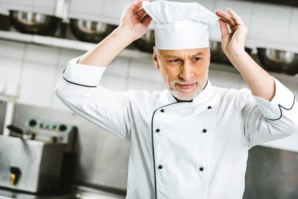Bonito Masculino Chef Uniforme Ajustando Cap Restaurante Cozinha — Fotografia de Stock