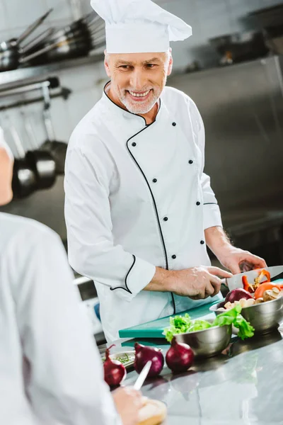 Sorrindo Chef Masculino Legumes Corte Uniformes Cozinha Restaurante — Fotografia de Stock