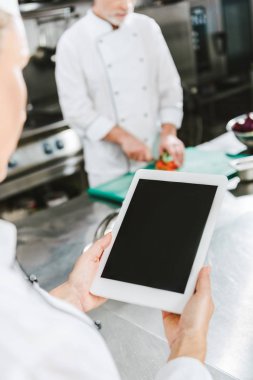 kısmi kadın şef Restoran mutfakta boş ekran ile dijital tablet kullanarak görünümünü