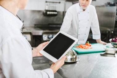kısmi kadın şef Restoran mutfakta boş ekran ile dijital tablet kullanarak görünümünü