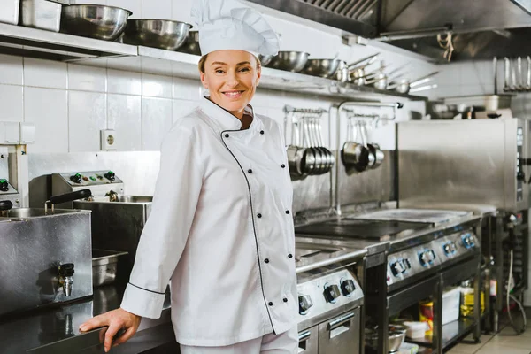 Atractiva Mujer Chef Sonriente Uniforme Sombrero Mirando Cámara Cocina Del — Foto de Stock