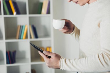 ebook ve çay elinde tutan adam eğitim kırpılmış görünümünü 