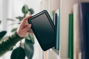 e-okuyucu bookshelf evde alarak kadının kırpılmış görünümü