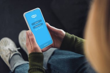 Kırpılan görünümünü smartphone twitter uygulaması ile ekranda tutan kadın 
