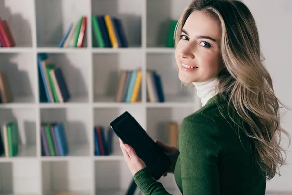 Mujer Feliz Sosteniendo Libro Con Pantalla Blanco Cerca Estantería Casa — Foto de Stock