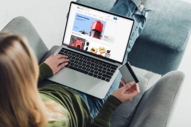 kredi kartı tutan ve ebey Web sitesinde ekran ile dizüstü bilgisayar kullanarak bir kadın görünümünü kırpılmış 