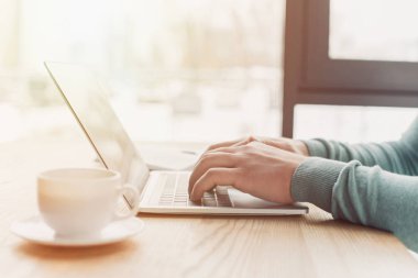 Evde çalışırken dizüstü bilgisayar kullanan adam kırpılmış görünümünü