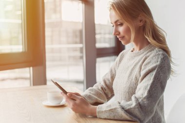 neşeli kadın evde ebook okunurken penceresine bakarak