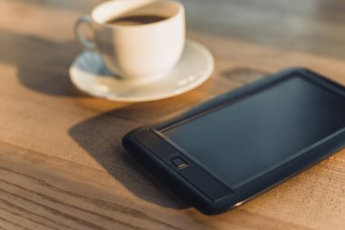 seçici odak Kupası masada içkiyle yakınındaki eBook