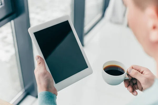 裁剪视图的人拿着杯子与咖啡和数字平板电脑与空白屏幕在手 — 图库照片