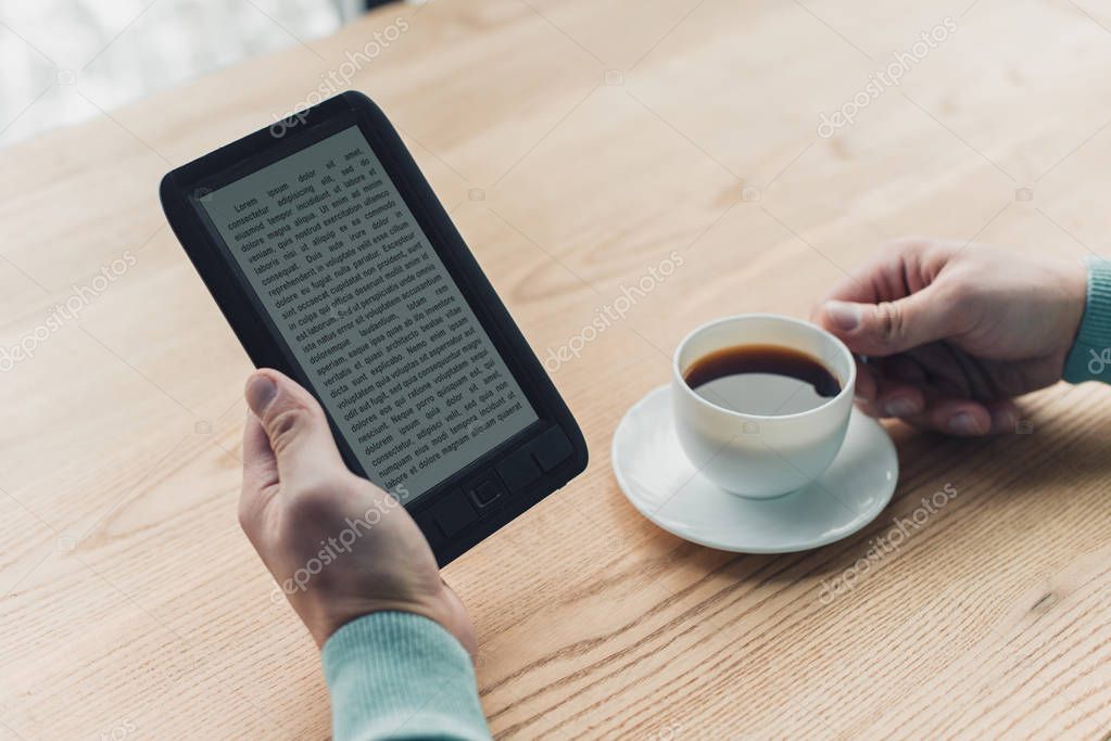 Cropped View Of Man Holding Cup Of Tea Near E Book While Studing At Home Larastock