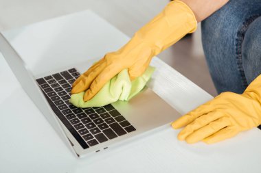 Laptop klavye bez ile temizlik sarı eldivenleri kadının kısmi görünümü