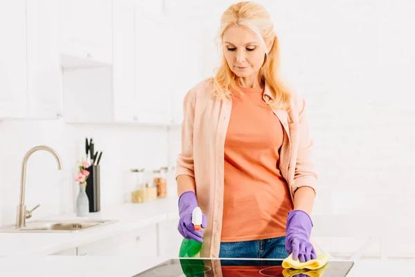 Ξανθιά Γυναίκα Ανώτερος Πλύση Κουζινών Σόμπα Πανί Και Σπρέι — Φωτογραφία Αρχείου