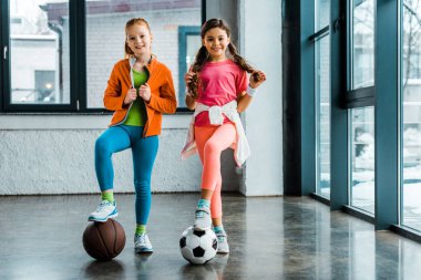 Kendine güvenen çocuklar spor salonu topları ile poz