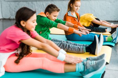 Çocuklar fitness paspaslar üzerine uzanan parlak giysili